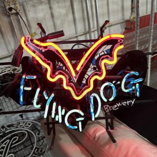 Neon sign for Flying Dog Brewery with bright colors and unique design, in working condition.