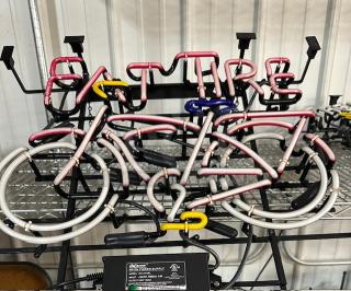Neon sign featuring "FAT TIRE" text and bicycle design. Multicolored tubing on black frame, in good condition.