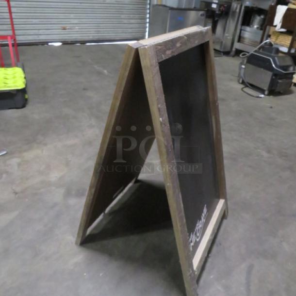 Wooden framed chalkboard sidewalk sign, 23.5x39 inches, in good condition. Foldable A-frame design, ideal for businesses.
