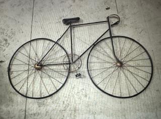 Metal wall decor shaped like a vintage bicycle, featuring intricate spokes and handlebars. In good condition.