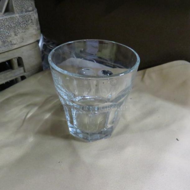 Clear glass rocks glass with a faceted design, good condition, no visible markings or labels, approximately 4 inches tall.