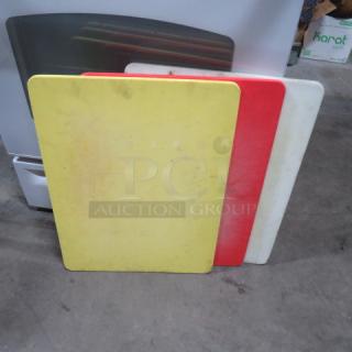 Assorted color 18x24 inch cutting boards; yellow, red, and white. Used condition, slight markings visible. Set of three.