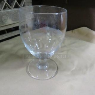 Clear stem water glass, model 12XBID, on beige surface. Simple, elegant design with a smooth finish in good condition.