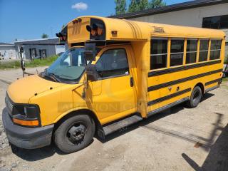 Yellow mini school bus with "Thomas Built Buses" logo, showing wear. Side reads "Jaffrey Rindge School District."