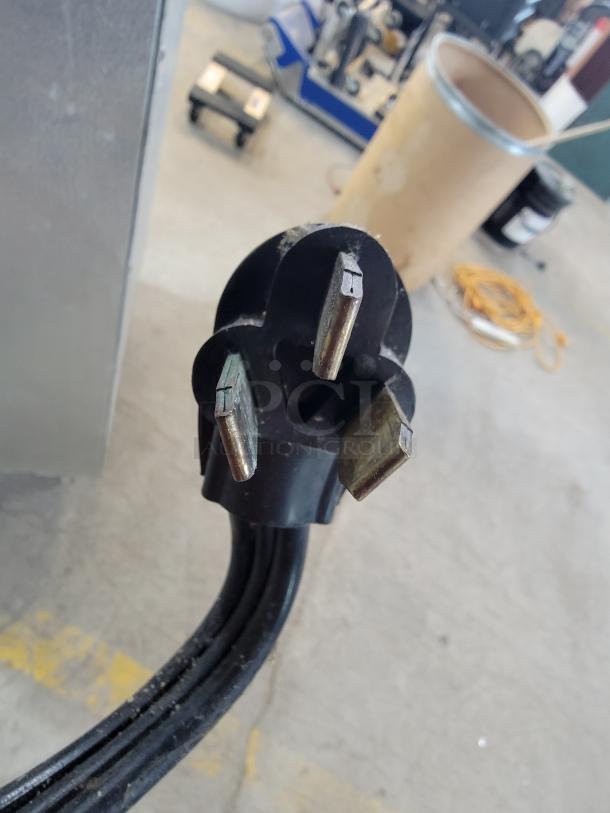 Power plug for True TRCB-110 110" 6-Drawer Commercial Chef Base, highlighting three-prong electrical connection.