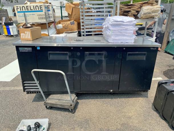 True TDD-4-HC commercial draft beer dispenser with 4 taps, black exterior, in used condition, suitable for bars or events.