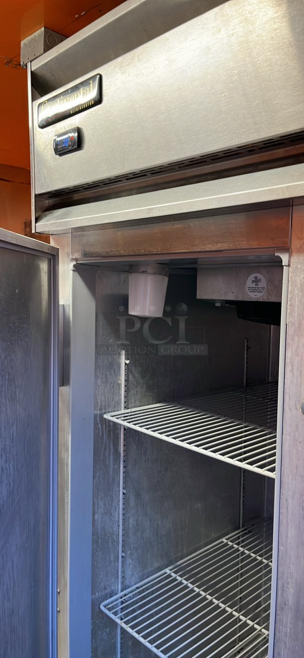 Continental commercial refrigerator inside 2014 Quality Trailers mobile kitchen; stainless steel, with shelving.