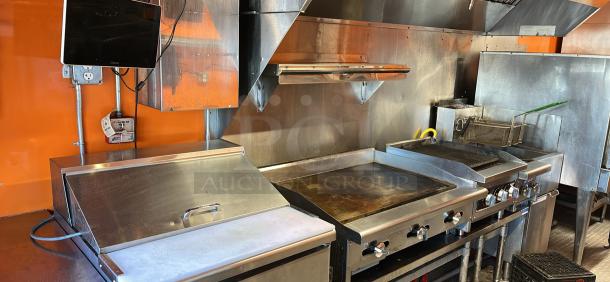 2014 Quality Trailers mobile kitchen interior with stainless steel appliances, griddle, fryer, and 8' hood. Ready to work.