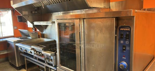 2014 Quality Trailers mobile kitchen interior with stainless steel appliances, including an Imperial oven and hood system.