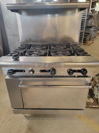 American Range commercial gas range with 6 burners and full-size oven. Stainless steel body, ideal for busy kitchens.
