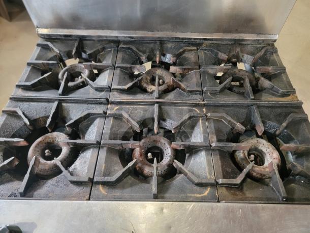 American Range commercial gas range with 6 open-top burners. Sturdy, professional-grade, ideal for busy kitchens.