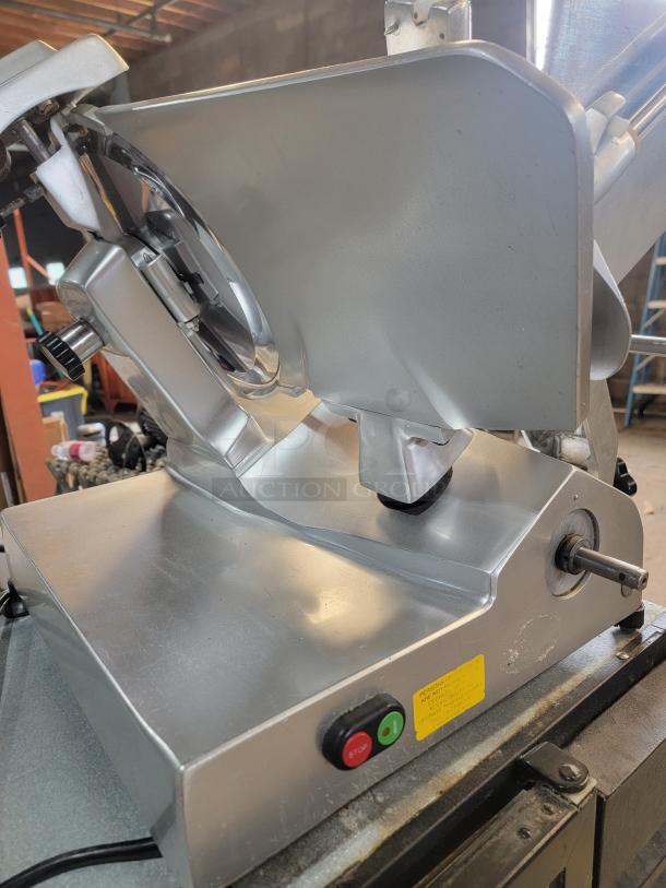Univex commercial meat slicer, heavy-duty, missing a knob. Used for precise slicing of meats, cheeses, vegetables.