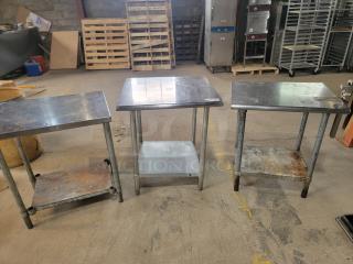Three stainless steel work tables with shelves, showing signs of wear. Includes Edlund commercial can opener.