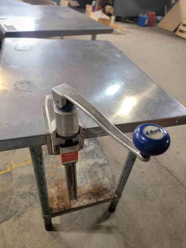 3 stainless steel work tables with Edlund commercial can opener attached, visible branding and usage marks.