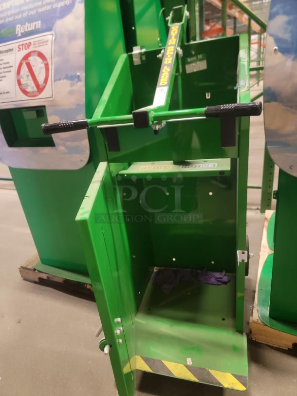 Green Zeus recycling compactor and hand baler in industrial setting, featuring robust metal construction and operation handle.