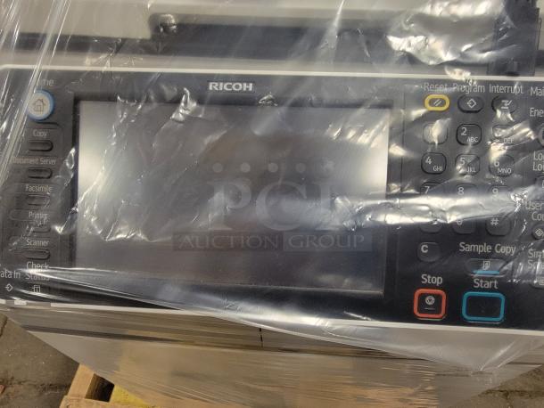 Ricoh MP 3554SP multifunction printer display, featuring print, copy, scan, and fax options. Wrapped in protective plastic.