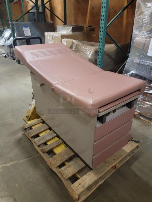 Ritter 104 Examination Table, heavy-duty with storage drawers, pink cushioned top, ideal for various uses, in good condition.