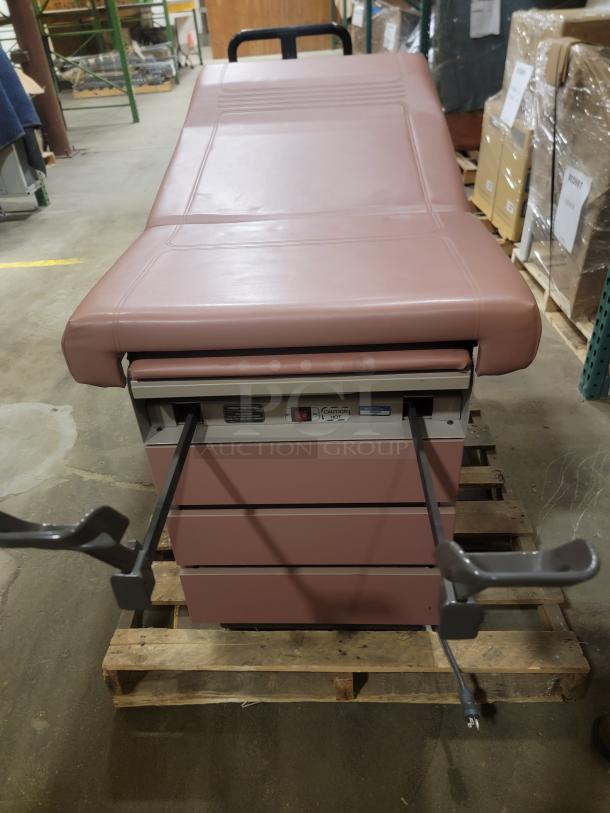 Ritter 104 exam table, heavy-duty, versatile use. Maroon upholstery, sturdy design, visible adjustment levers, ideal condition.