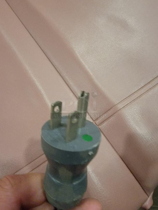 Ritter 104 Heavy Duty Power Table plug shown against padded examination surface, green dot marking visible.