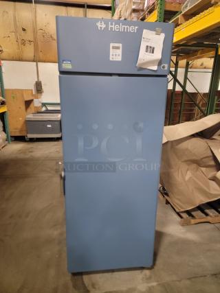 Helmer HLF120 Horizon Series medical-grade freezer, blue, with visible labels and papers on the door.