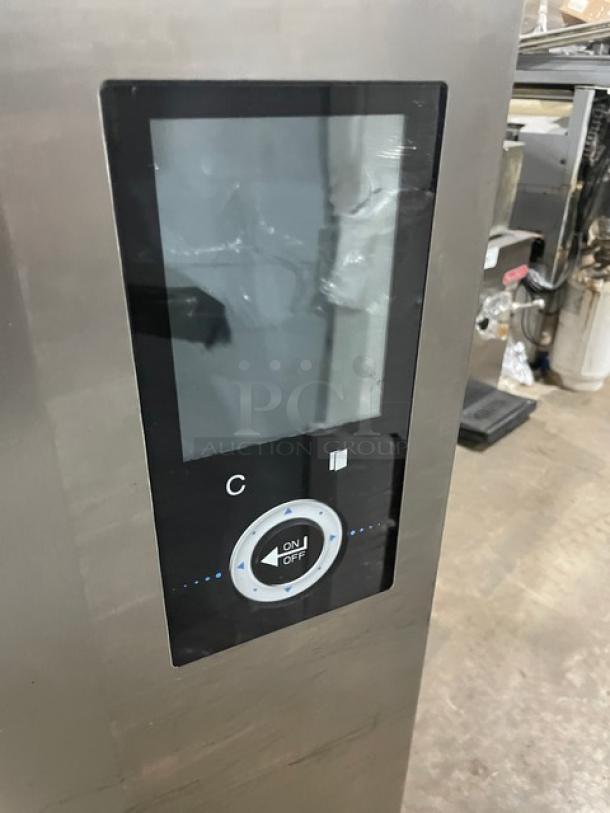 Industrial control panel with touchscreen display, stainless steel casing, circular on/off button, minor wear visible.