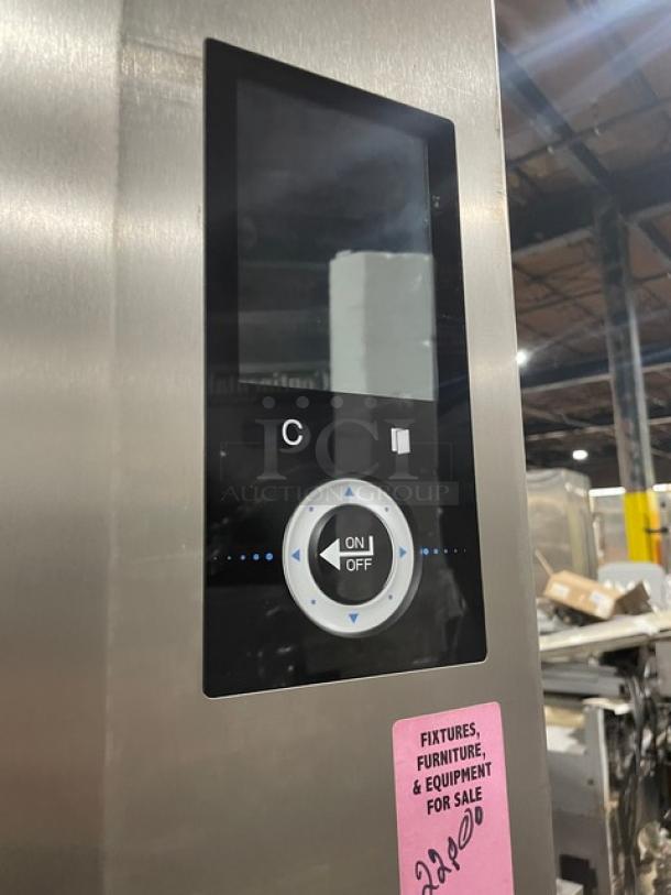 Stainless steel control panel with digital display, prominent on/off button, and selector dial. Pink label with auction info.
