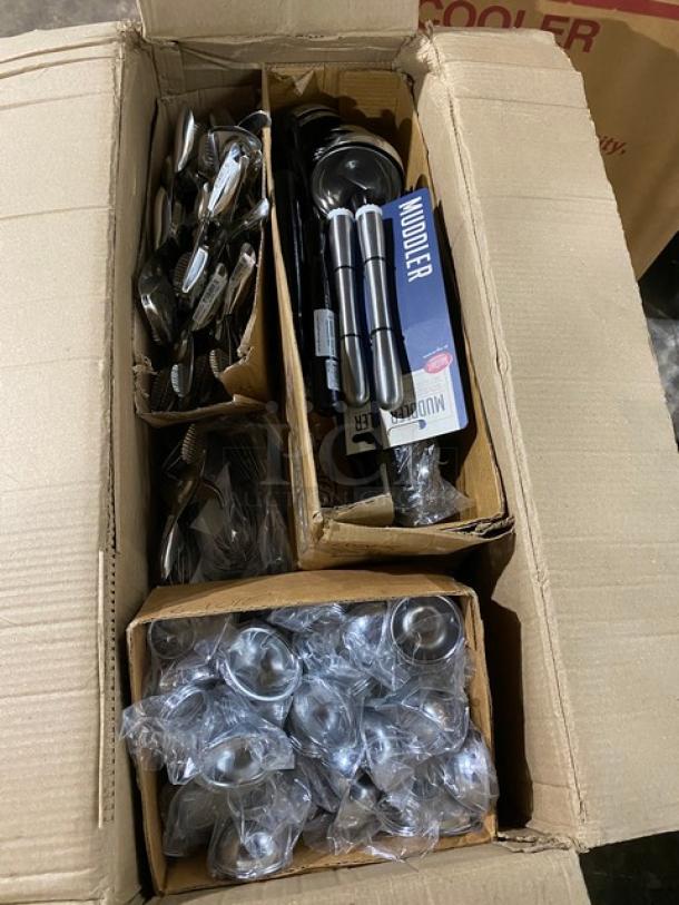 Box with assorted stainless steel bartending tools, including muddlers and jiggers, in new packaging.