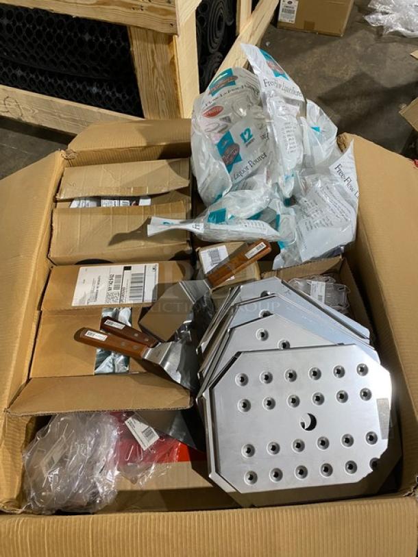 Box containing metal spatulas with wooden handles, perforated metal plates, and packaged kitchen supplies. Appears new and unused.
