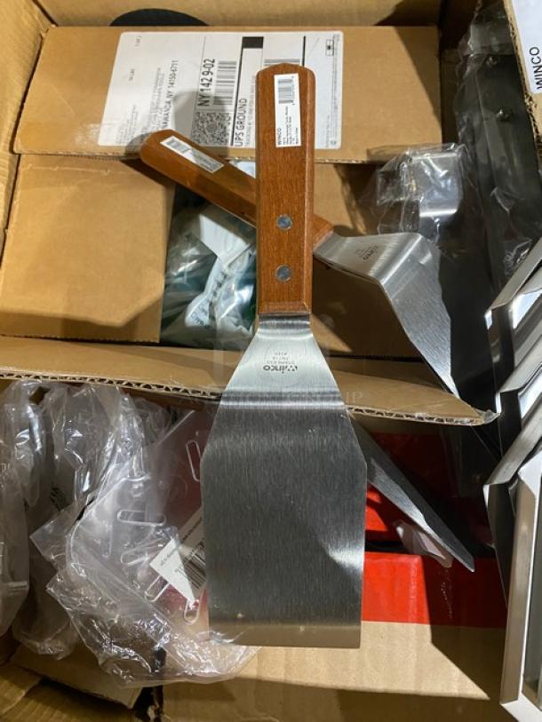 Metal spatula with wooden handle, marked "Winco," new in cardboard box.
