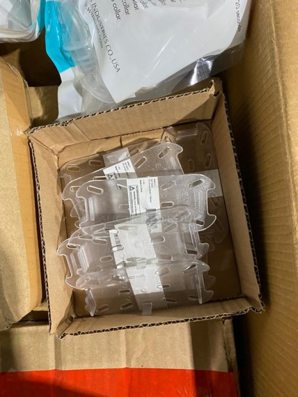 Clear plastic brackets in a cardboard box, unused with labels. Labels show manufacturer info and installation instructions.