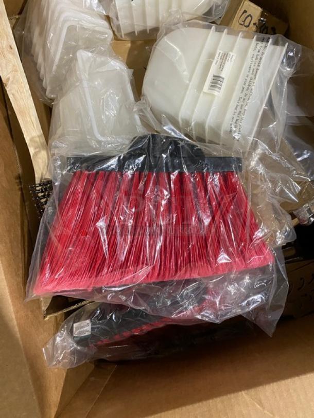 Red broom head with black attachment in plastic wrap, new condition. Boxed with similar items; durability evident.