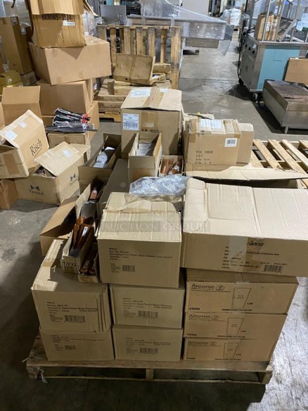 Assorted sealed cardboard boxes on a pallet, labeled with "Arcoroc," indicating bulk glassware storage. Boxes show some wear.