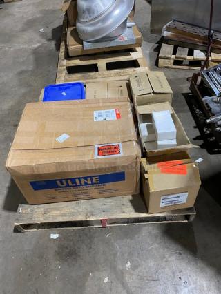 Assorted shipping boxes on a pallet, including a large Uline box. Labels indicate sealed packages and shipping details.