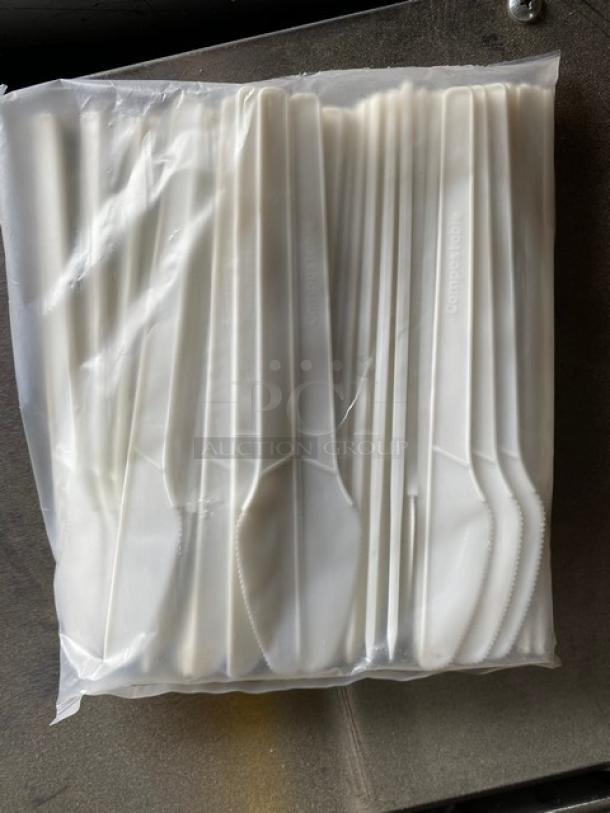 Pack of white plastic knives labeled "Compostable," in clear packaging, new condition.
