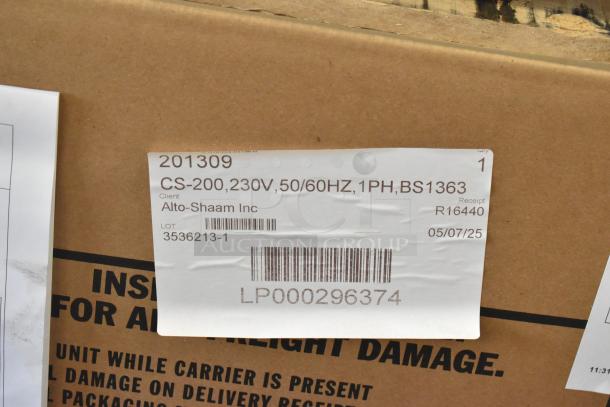 Brand new Alto Shaam CS-200 carving station in box. Stainless steel, dual lamp, 230V, 1 phase, model details visible.