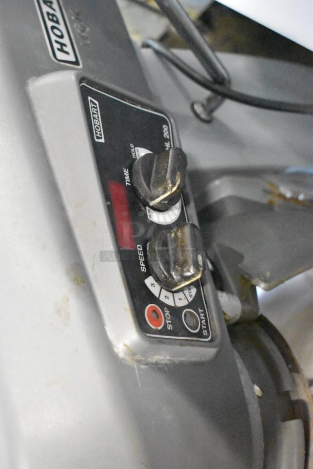 Hobart Legacy HL200 commercial mixer panel, showing speed and timer controls. Features worn dials and visible brand label.