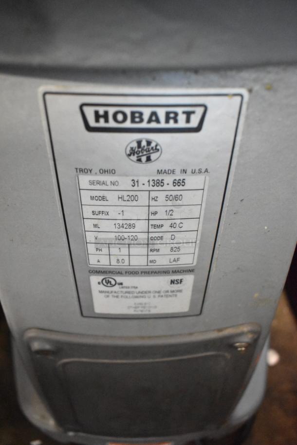 Hobart Legacy HL200 20 Qt. metal dough mixer with bowl and whisk; badge shows serial, model, and voltage information.
