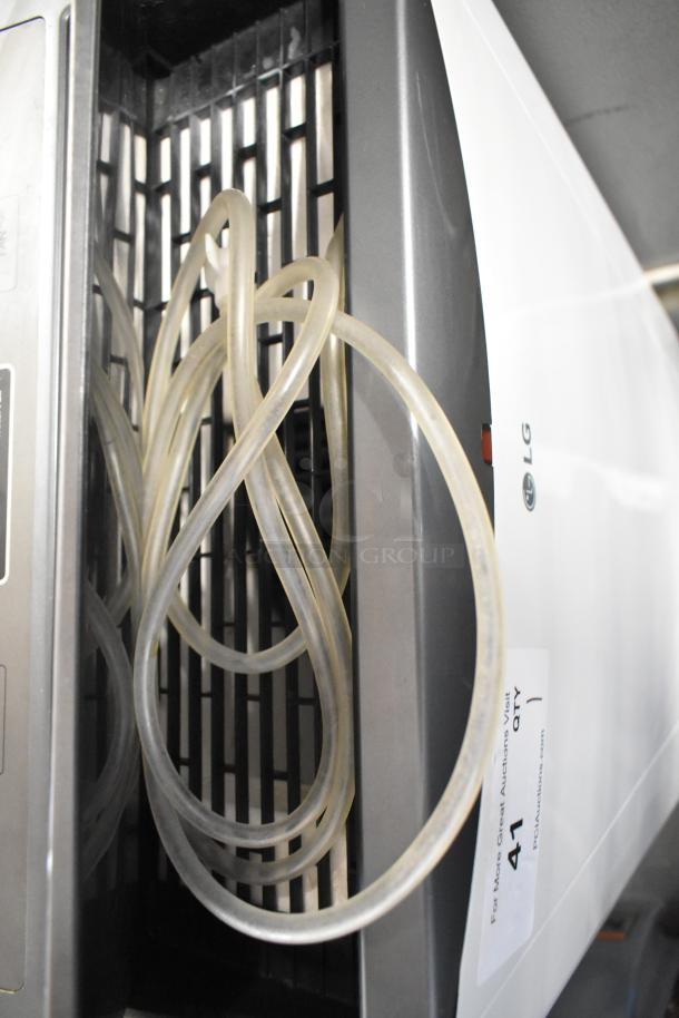 LG LP1415WXRSM Portable Air Conditioner with hose. 14,000 BTU, 115 Volts, 1 Phase. Model tag visible.