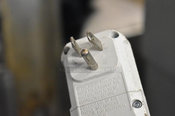 Close-up of the LG LP1415WXRSM air conditioner plug with visible warning text. Plug shows some wear.