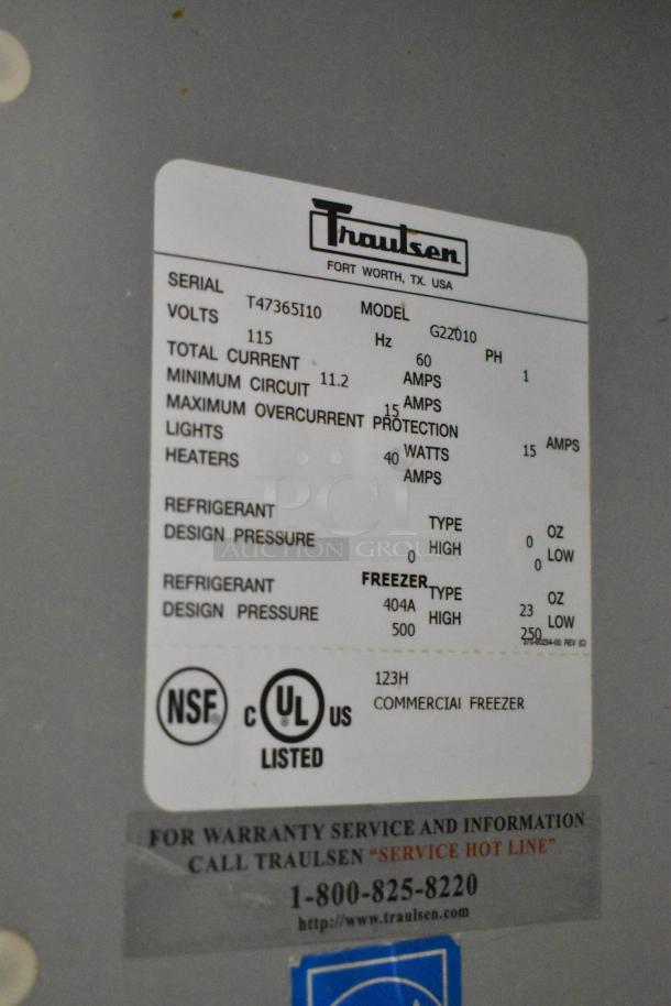 Traulsen G22010 stainless steel 2-door commercial freezer with poly racks, 115V, model label showing specs and certifications.