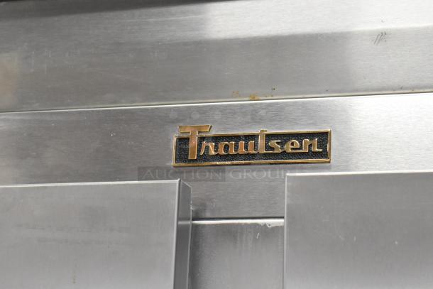 Traulsen G22010 stainless steel 2-door commercial freezer, features poly coated racks and commercial casters, logo detail shown.