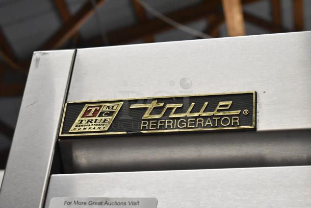 True T-49 stainless steel 2-door commercial cooler, poly-coated racks, on casters, logo plaque visible, 115V 1 phase.