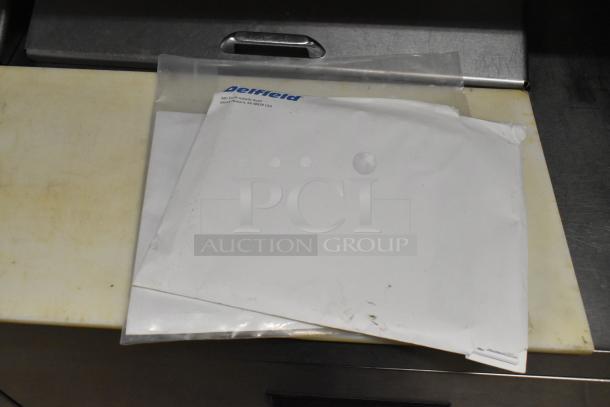 Delfield UCD4464N-12-DD5 sandwich salad prep table, stainless steel, 4 drawers, over shelf, visible Delfield paperwork.