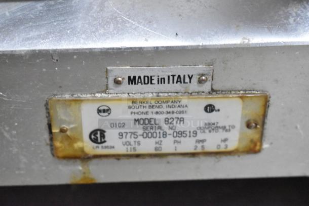 Berkel 827A commercial meat slicer label on metal surface, showing model, serial number, voltage, and "Made in Italy".