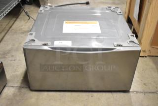 LG WDP4V stainless steel pedestal for washer/dryer, top view. Durable, sleek design, minor surface wear visible.