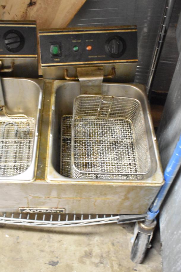 Adcraft stainless steel double fryer with two baskets, electric, 120V, 1 phase. Shows wear, suitable for commercial use.