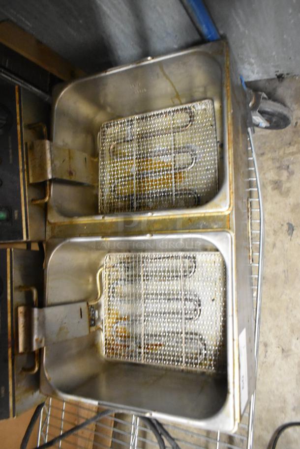 Adcraft stainless steel double fryer with 2 metal baskets. Electric, 120V, 1 Phase. Some visible wear, suitable for commercial use.