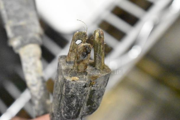 Close-up of an electrical plug with two prongs; possibly showing wear, for an Adcraft commercial fryer.