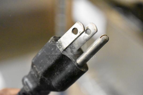 Power plug for Brother HL-L2380DW copier printer fax machine, showing prongs and partial view of cord.