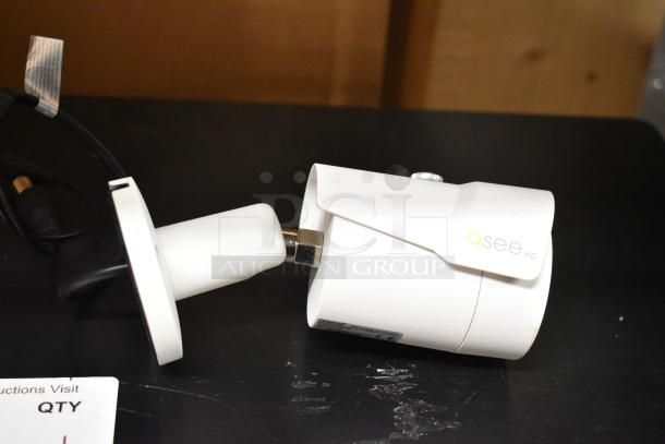 Qsee QCA8075B security camera, white, HD, cylindrical design, intact condition with visible Qsee branding and connection cable.